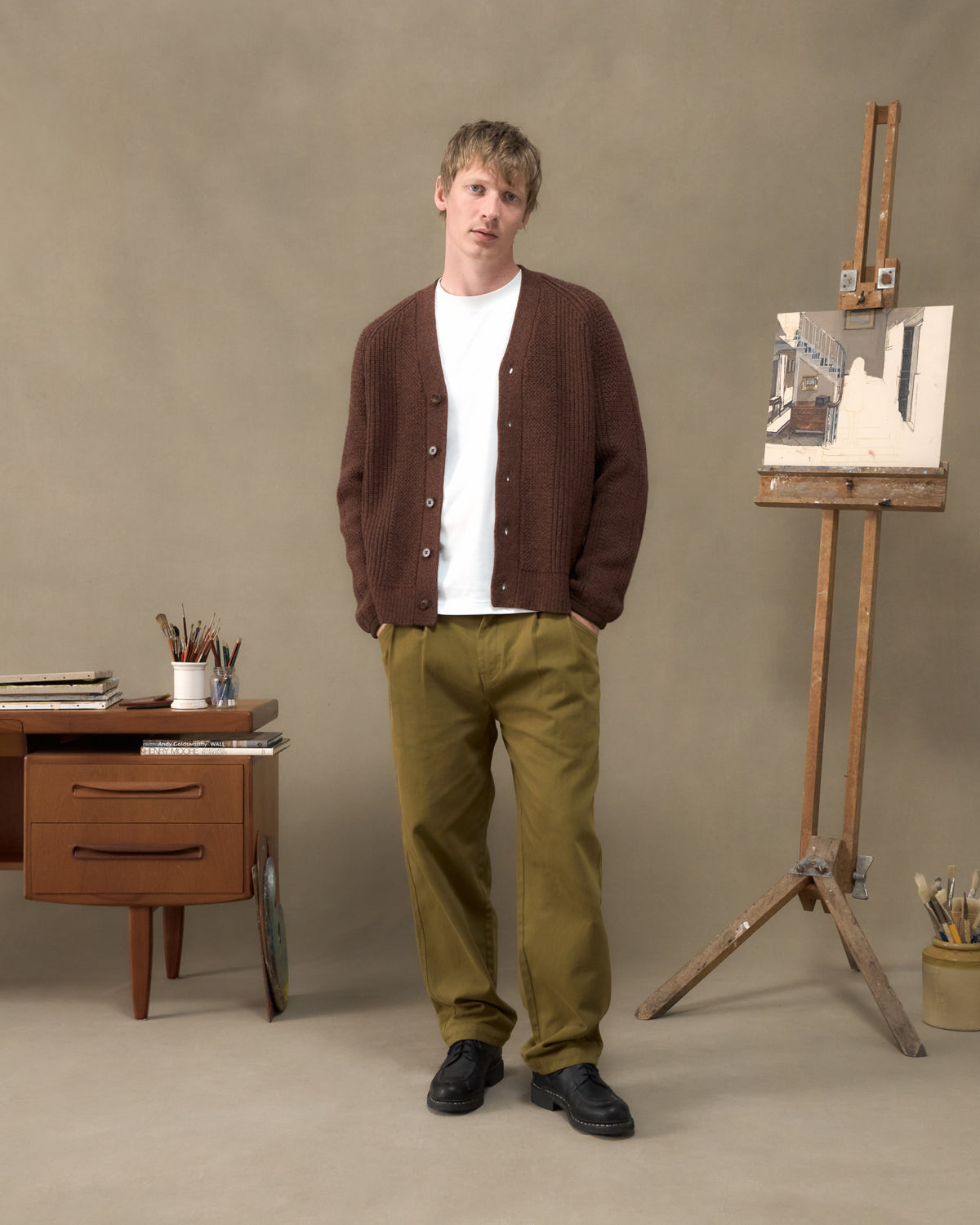 Model wearing the Fera Brigade Cardigan in Brown Marl with Fera Uniform Trousers in Moss