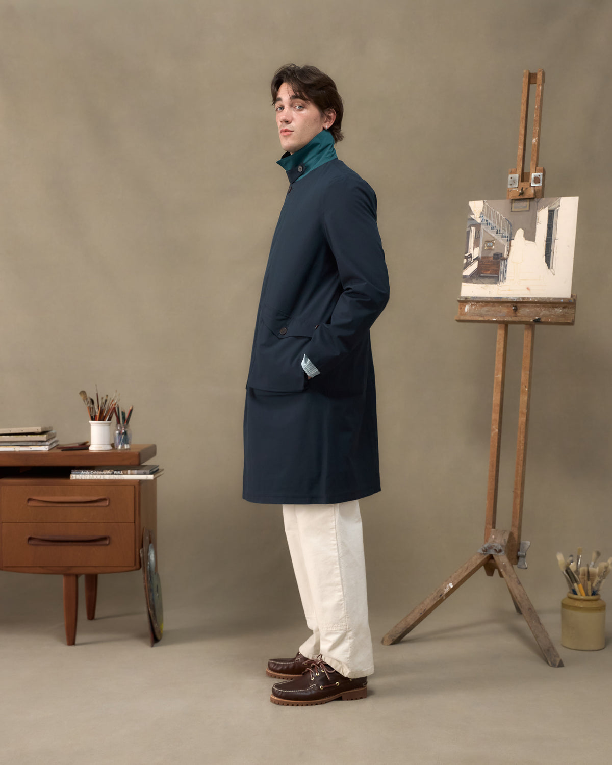 Model wearing the Fera Marwood Coat in Navy, side view with the storm collar raised