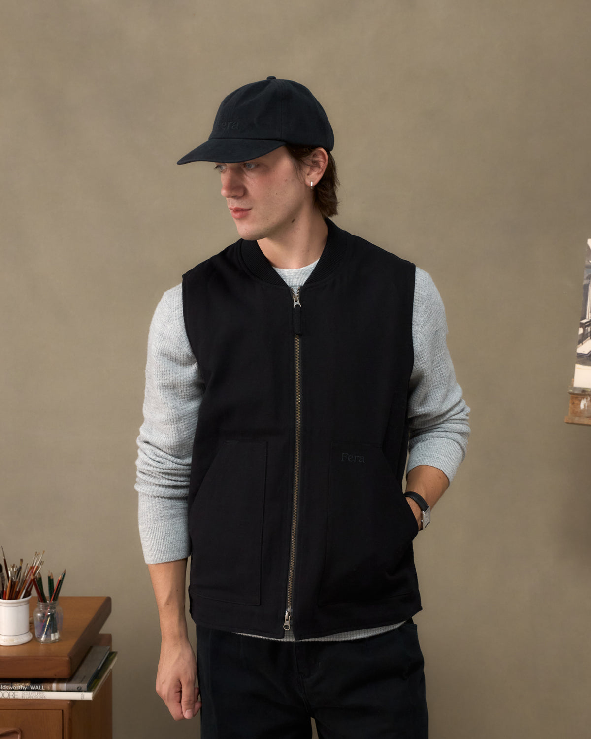 Model wearing the Fera Poacher Gilet in Black with a Fera cap, front view