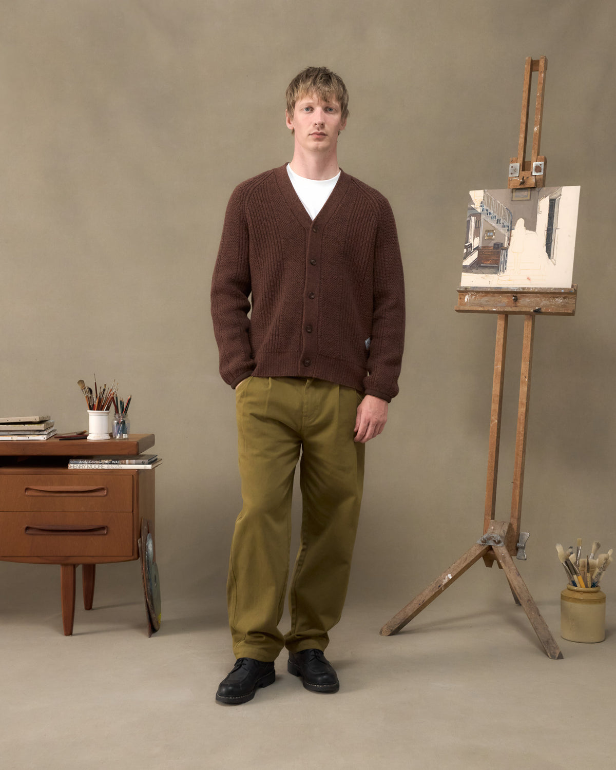 Model wearing the Fera Brigade Cardigan in Brown Marl with Fera Uniform Trousers in Moss
