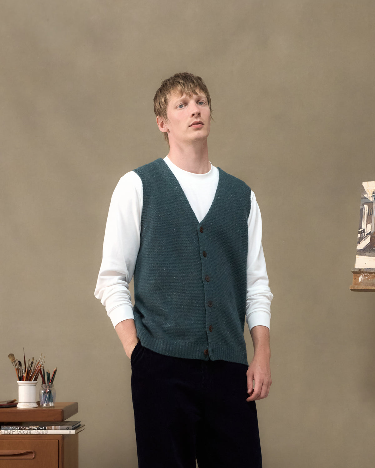 Model wearing the Fera Curlew Merino Vest in Green Donegal over a white long sleeve