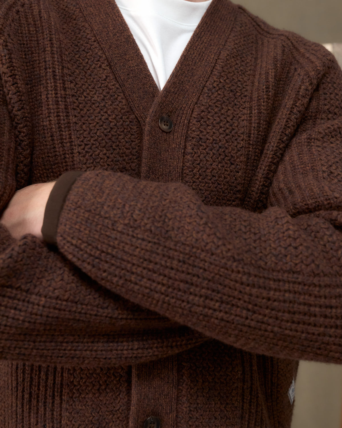 Close-up of the Fera Brigade Cardigan in Brown Marl showing the racked rib knit and button placket