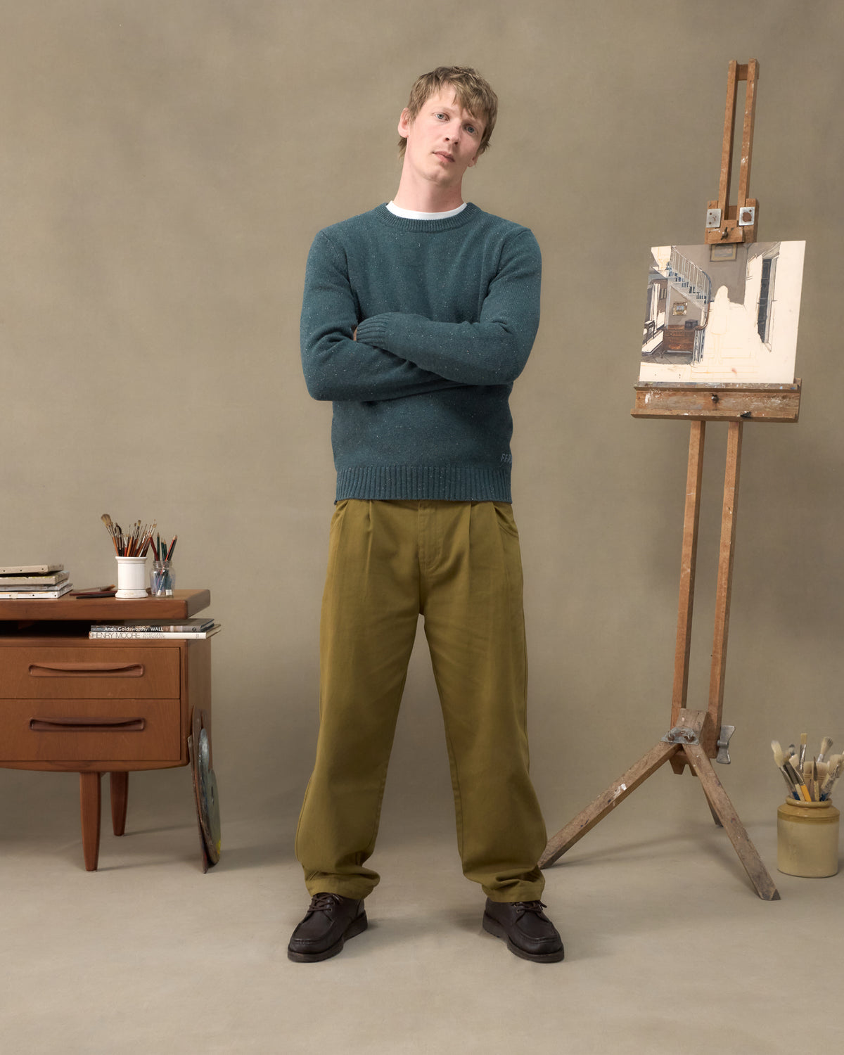Model wearing the Fera Peewit Knit in Green Donegal with Fera Uniform Trousers in Moss, arms folded