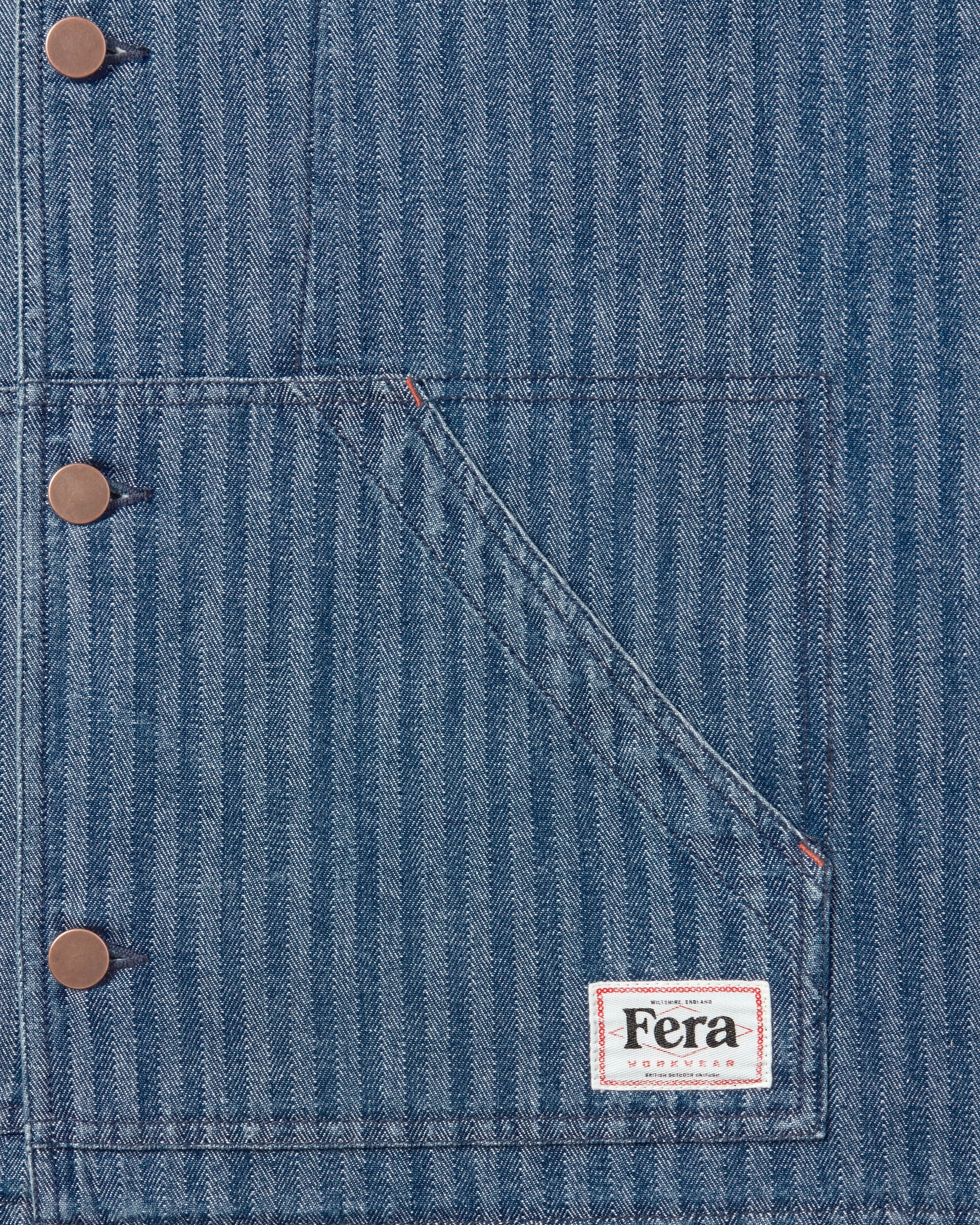 The Fera Uniform Jacket in striped denim, a button-up jacket with a stand collar. And the Fera Workwear Label.