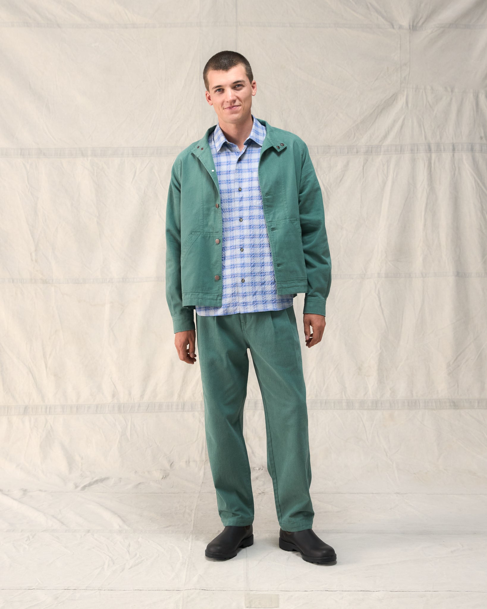 Our Fera Uniform Trousers are cut from a 250gsm washed green cotton and pair a wider, relaxed leg with refined double pleats at the waist.